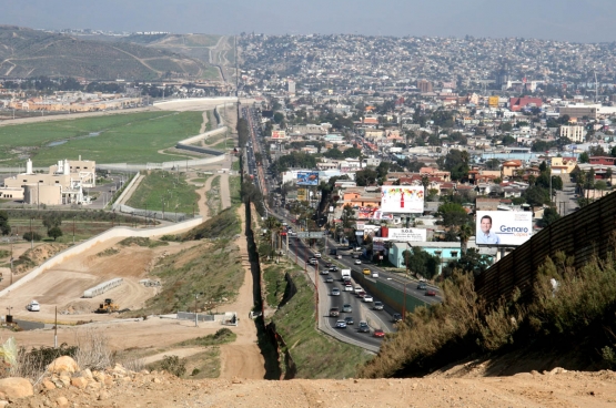 À droite, la ville de Tijuana, au Mexique, où sont installées de nombreuses usines de production qui dépendent de multinationales américaines. À gauche, les États-Unis. Entre, la frontière, sur laquelle s’érige déjà une imposante barrière. (Photo Gordon Hyde / Wikimedia)