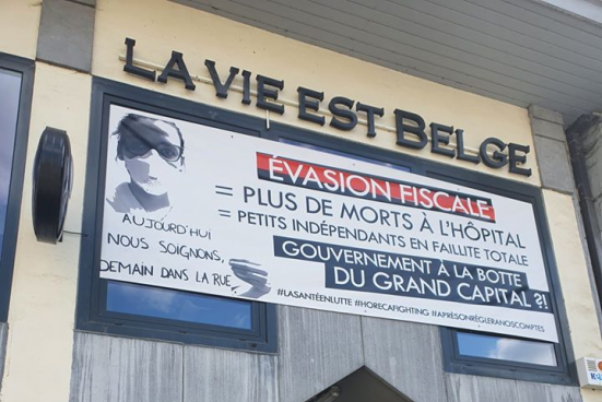 Une banderole pour interpeler le gouvernement sur la façade de l'établissement "La vie est belge". (Photo : Amin Brikci)