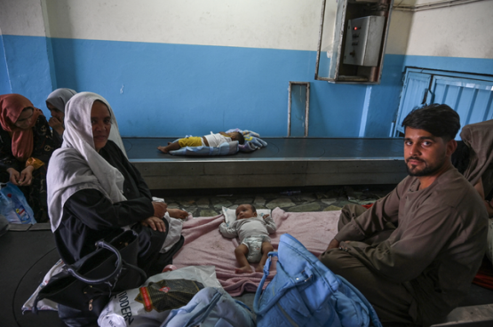 Un couple afghan change la couche de son bébé à l'aéroport. Le résultat de l'ingérence occidentale. (Photo Belga)