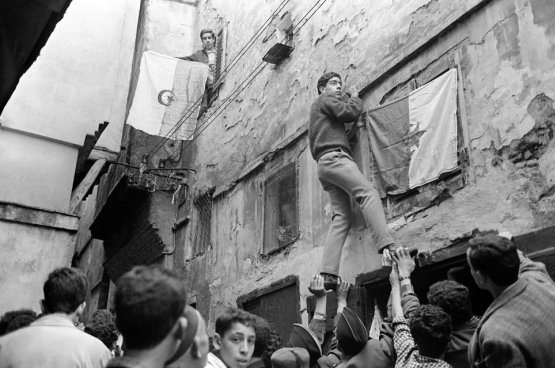 Des jeunes accrochent des drapeaux algériens à Alger en juillet 1962, après plus de 130 ans de colonisation française. (Photo AFP)